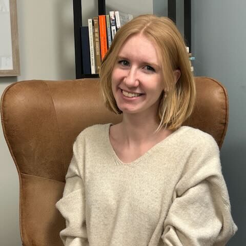 Bekah | Marble Wellness Client Care Coordinator Bekah Drummond, Client Care Coordinator for St. Louis Therapists at Marble Wellness sitting and smiling at the camera.